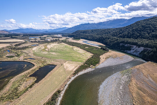 Aerial view of the winding river cutting through the landscape, contrasting with the lush green fields and dark pools near 146 Jericho Road, Blackmount, Southland Region, New Zealand.