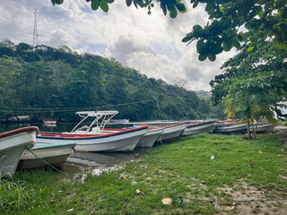 Tranquil landscape of a line of traditional fishing boats moored on the bank of a tropical river