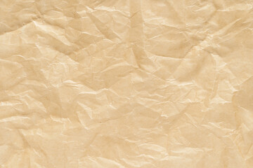 Obraz premium Close-up of crumpled brown paper texture with wrinkles and creases for craft and design projects.