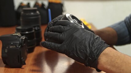 Close-up of a professional photographer adjusting the aperture and focus rings on a camera lens. Sharp detail on lens markings and mechanical movement.