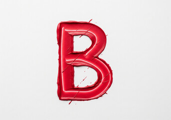 A bold, capital letter B drawn with a single, creamy lipstick stroke. Textural streaks and opacity variations reveal its sensual, physical creation against a stark, pure white background.