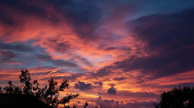 A glowing sun setting behind orange and pink clouds expresses warmth, transition, and the emotional beauty of the changing sky.
 - Powered by Adobe