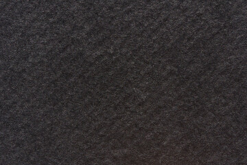 Dark textured surface with subtle patterns and soft material appearance.