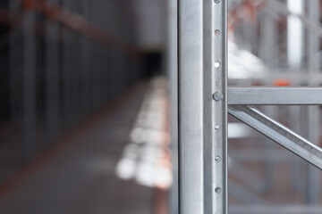 Background industrial metal shelving racks in a warehouse or factory. The steel structure with orange beams and metal efficient storage system. Logistics industrial design concepts