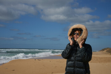 Woman enjoying cold winter day on sandy beach