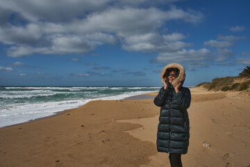 Woman enjoying cold winter weather at the beach