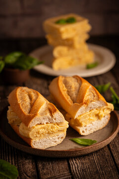Spanish potato omelette sandwich. Typical Spanish food, Bocadillo de tortilla espanola very popular snack in Spain on white rustic background