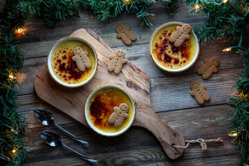 Top down view of homemade Creme Brulee servings with gingerbread men cookies.