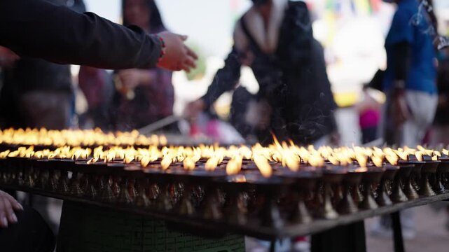 Close-up of rows of butter lamps glowing during a Buddhist ceremony in Nepal.
