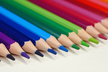 Naklejka premium New wooden colored pencils of rainbow colors, perfectly sharpened, lie on table