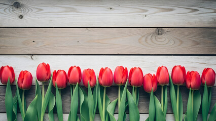 Row of red tulips against wooden background