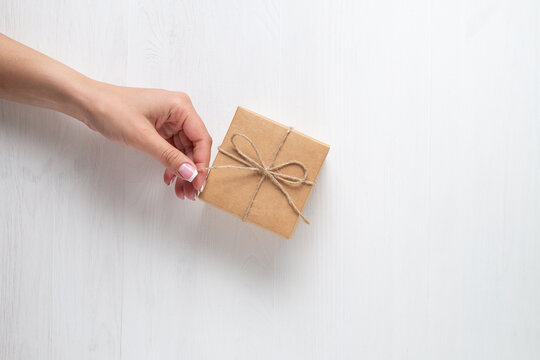 Hand pulling string on paper package