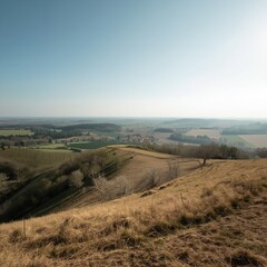 Obraz premium Panoramic View of Rolling Hills and Farmland Under Clear Sky