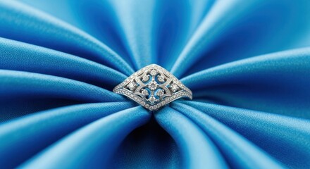 A diamond ring is displayed on a luxurious blue silk background.