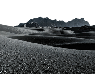 Stark grayscale landscape with rolling hills, textured ground, and distant jagged mountains silhouetted