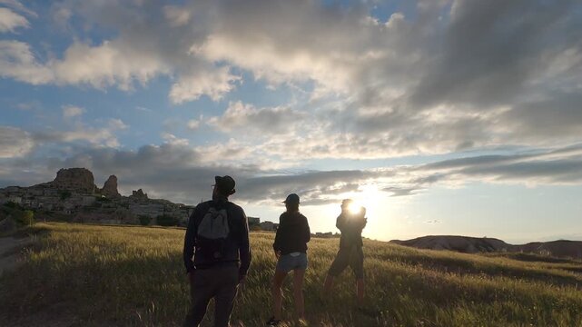 Group of friends enjoying sunset while photographing Uchisar town in Cappadocia, Turkey