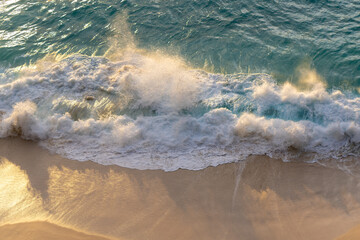Aerial Top-Down View of a Beach with Gentle White Foamy Waves at Golden Hour. High quality photo