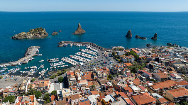 Aerial view of the town of Aci Trezza overlooking the Mediterranean Sea, in the province of Catania, Sicily, Italy. In the background, on the horizon, are the Cyclopean Isles or islands of the Cyclops