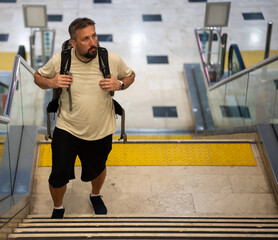 Middle aged bearded man traveling. Finding his way in the airport. High quality photo