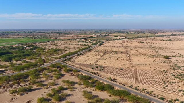 Drone captured cinematic views of the Cholistan Desert and Derawar Fort in Pakistan, vast golden sand dunes and historic fortress landscape filmed from an overhead aerial perspective during daytime, i