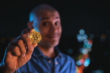 Man holding a golden bitcoin coin representing cryptocurrency investment and the future of finance
