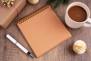 High angle view of blank notepad and cup of mocha on wood block