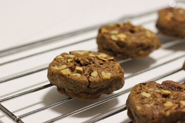 Fototapeta premium Close up of a homemade chocolate chip cookie with nuts on a cooling rack