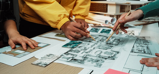 Designers engage in collaborative sketching and planning, showcasing hands working with colorful materials and detailed blueprints on a drafting table. SACTR