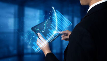A business professional engaged in analyzing financial data displayed on a digital tablet, showcasing growth trends and analytics in a modern office setting. Impute