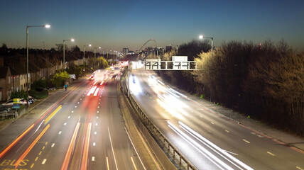 Obraz premium Long Exposure of City Highway Traffic at Twilight with Motion Blur Lights