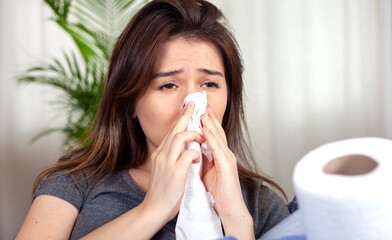 young woman blowing her nose