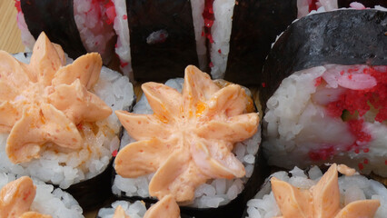 Sushi rolls with colorful filling served on a wooden plate in a dining setting during lunch time
