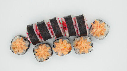 Different types of sushi arranged on a white surface, showing colorful fillings and shapes