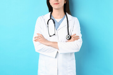 Fototapeta premium Doctor in medical uniform with stethoscope on light blue background, closeup