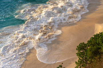 Aerial Top-Down View of a Beach with Gentle White Foamy Waves at Golden Hour. High quality photo