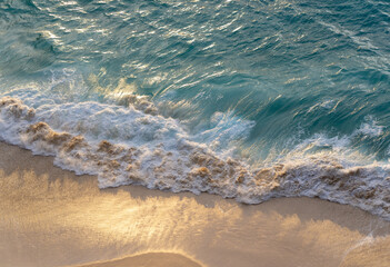Aerial Top-Down View of a Beach with Gentle White Foamy Waves at Golden Hour. High quality photo