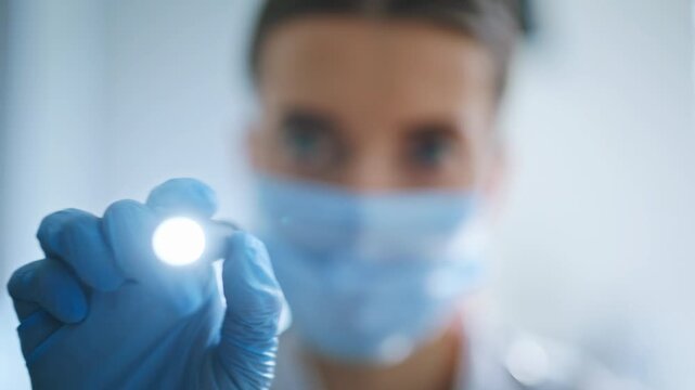 Therapist checking light reaction in clinic ward. Doctor with flashlight closeup