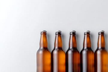 Five amber glass bottles with silver caps stand upright, lined up perfectly on clean light background, copy space