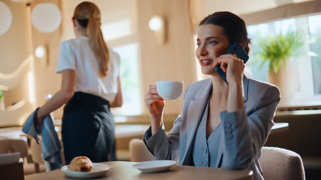 Confident manager calling cafeteria sitting small table. Businesswoman talking
