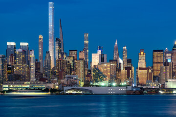 The impressive Midtown Manhattan skyline featuring the ultra thin skyscrapers of Billionaires Row illuminated at night.