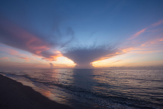 Dramatic Sunrise Over Calm Ocean With Towering Cloud Formation - Powered by Adobe