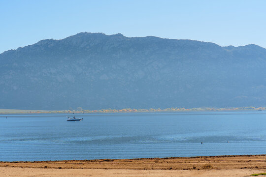 Tranquil Lake Perris Scene With Distant Mountains And Boater