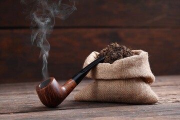 Wooden pipe with tobacco in burlap bag on rustic wooden tabletop