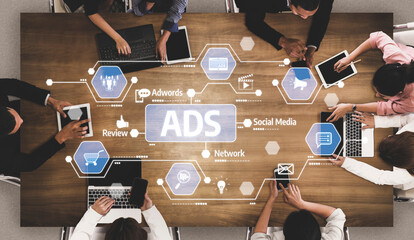 A diverse team engages in a collaborative planning session at a stylish table, surrounded by laptops and smart devices focused on digital marketing for advertising strategies. Tessel