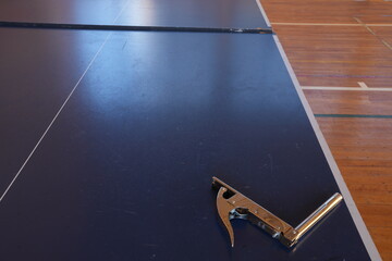 Obraz premium A metal object is on a blue surface. The surface is a table. The object is a bottle opener