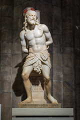 Obraz premium Milan, Italy - December 14, 2025: Marble statue of Christ bound before the Passion inside Milan Cathedral (Duomo di Milano), illuminated against dark stone columns.