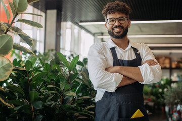 Happy male florist manager standing in plant shop