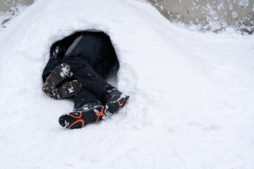 Person Sleeping or Hiding Inside a Snow Hole. High quality photo