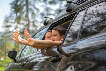 Kids Stretching Hands out of Car Window Enjoying the Fresh Air. High quality photo