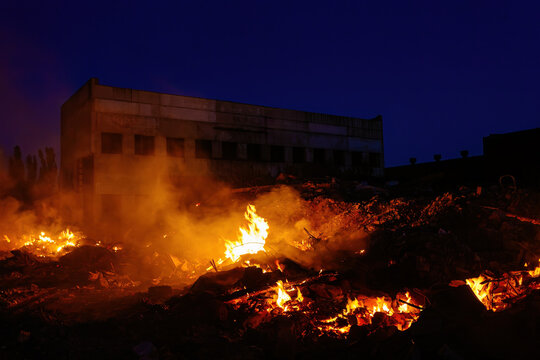 Burning building ruins at night after fire or attack